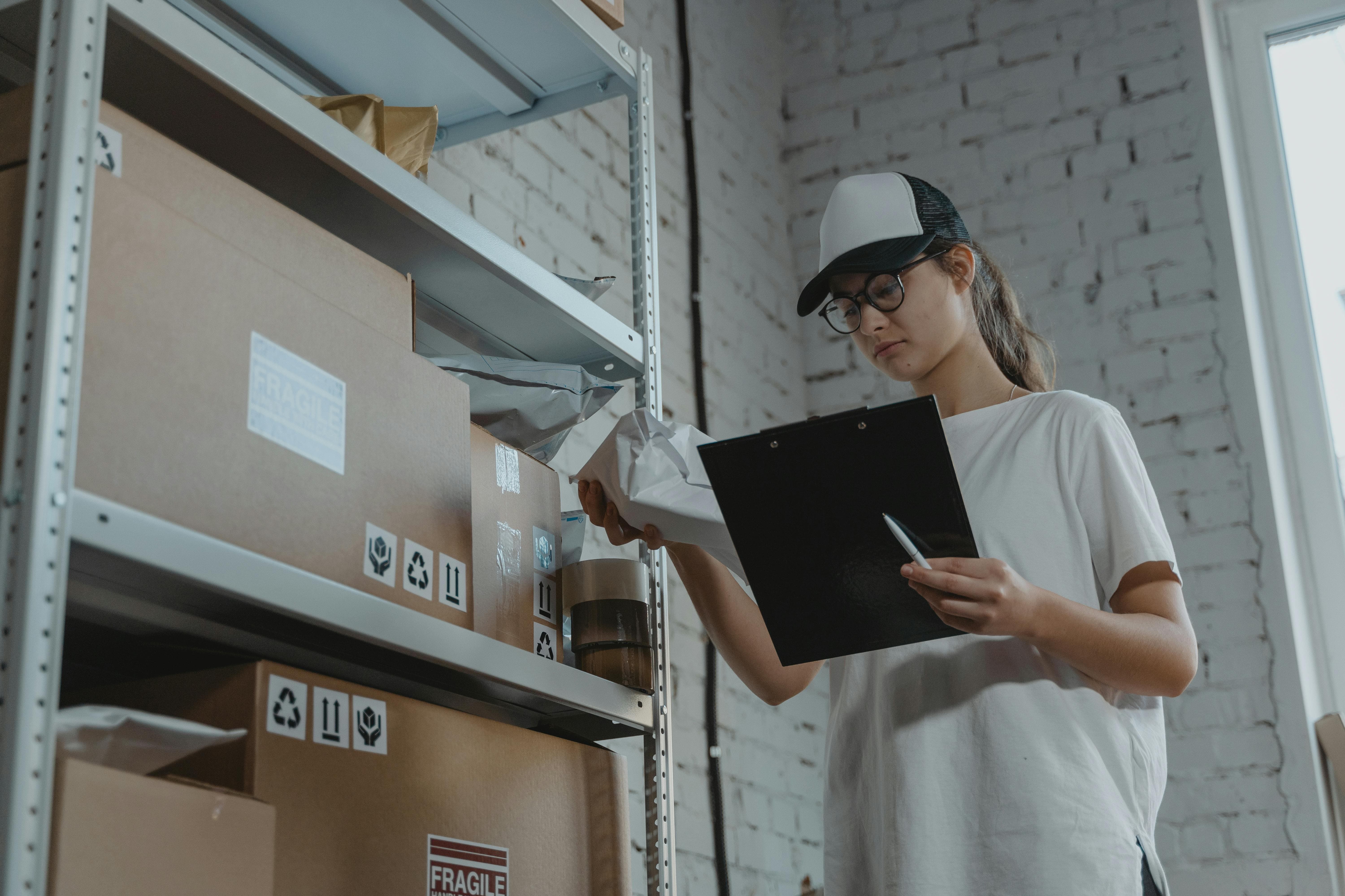 Storemove warehouse worker organising and auditing business storage boxes on shelves in a secure facility