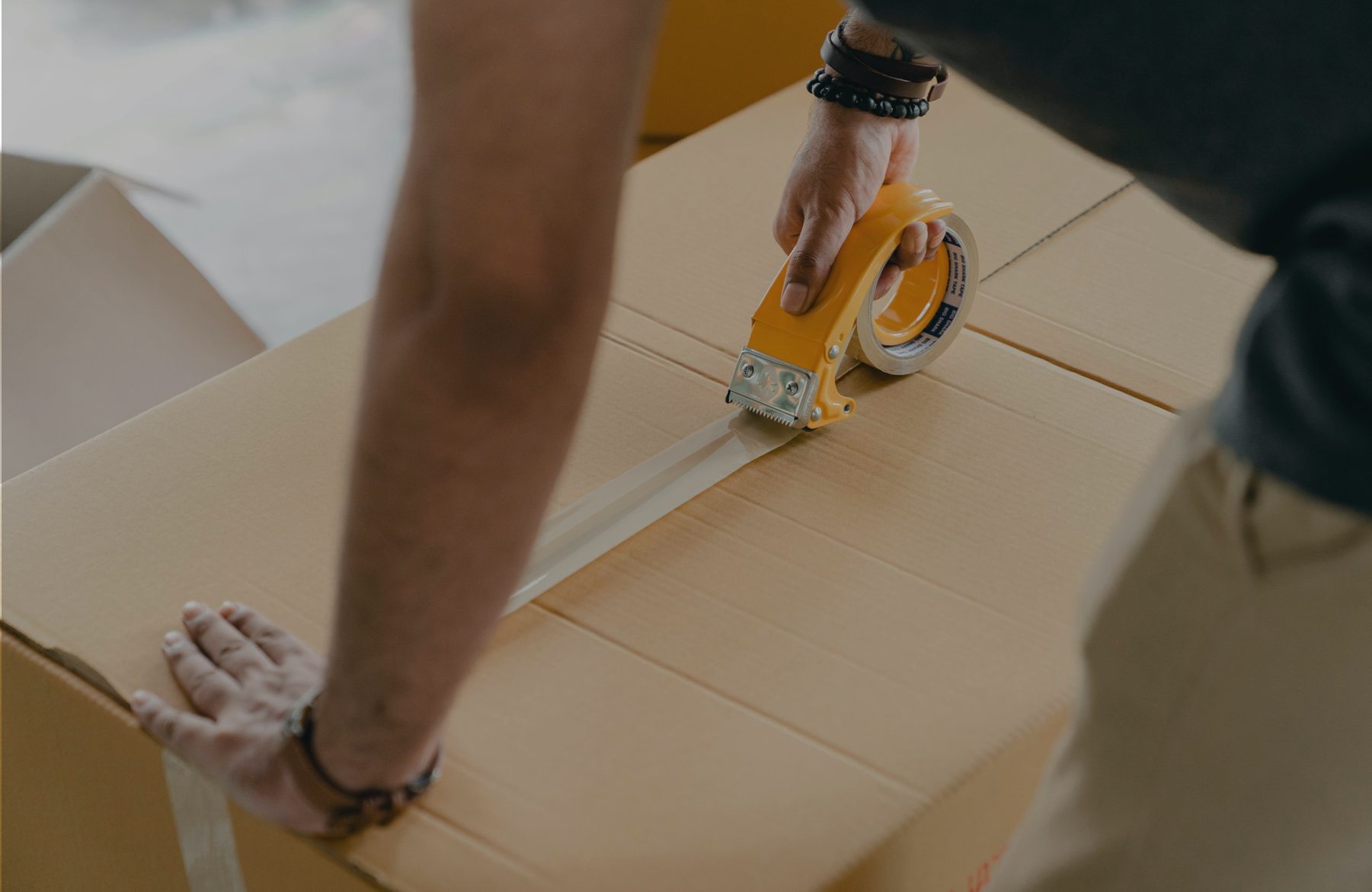 Storemove team member applying secure tape to a moving box for a customer